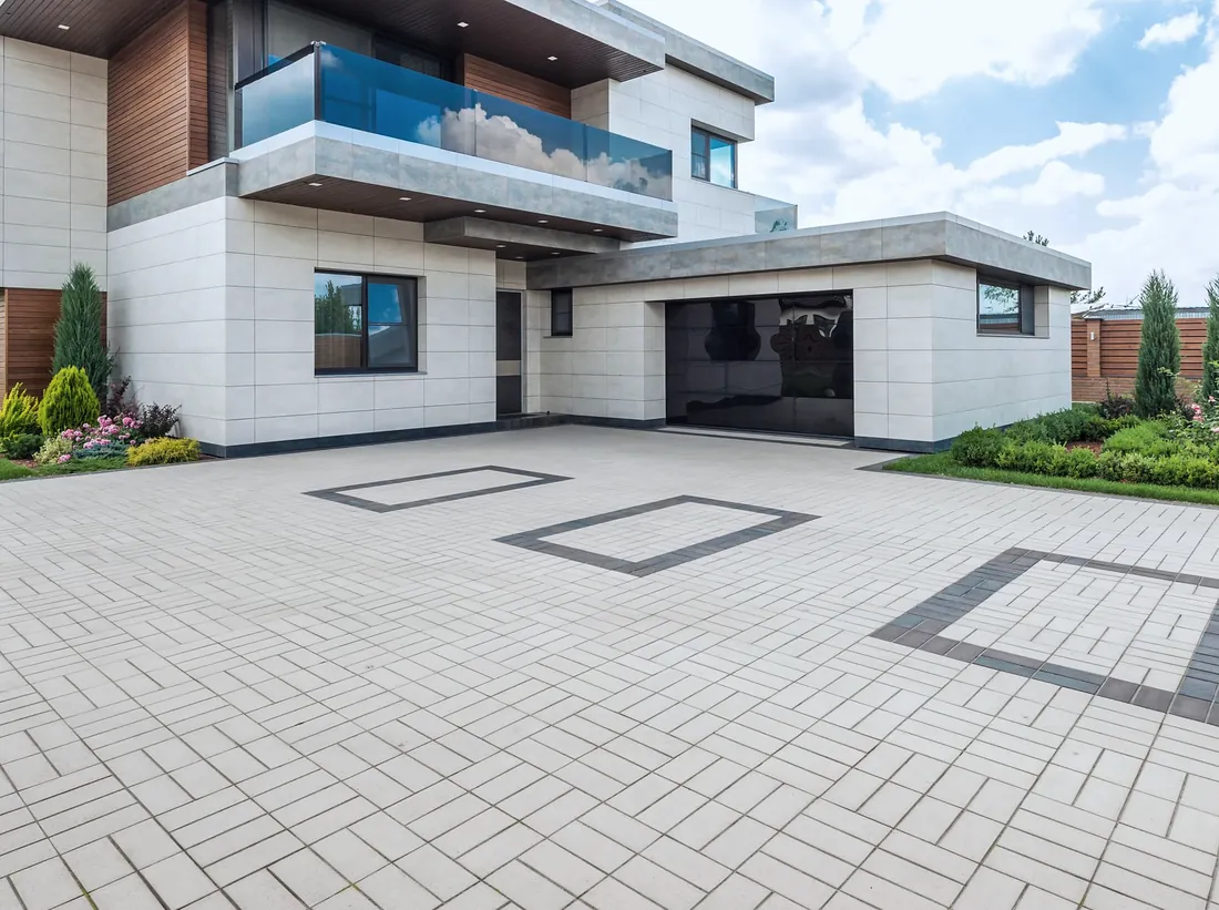 A wide paved driveway in front of a modern home