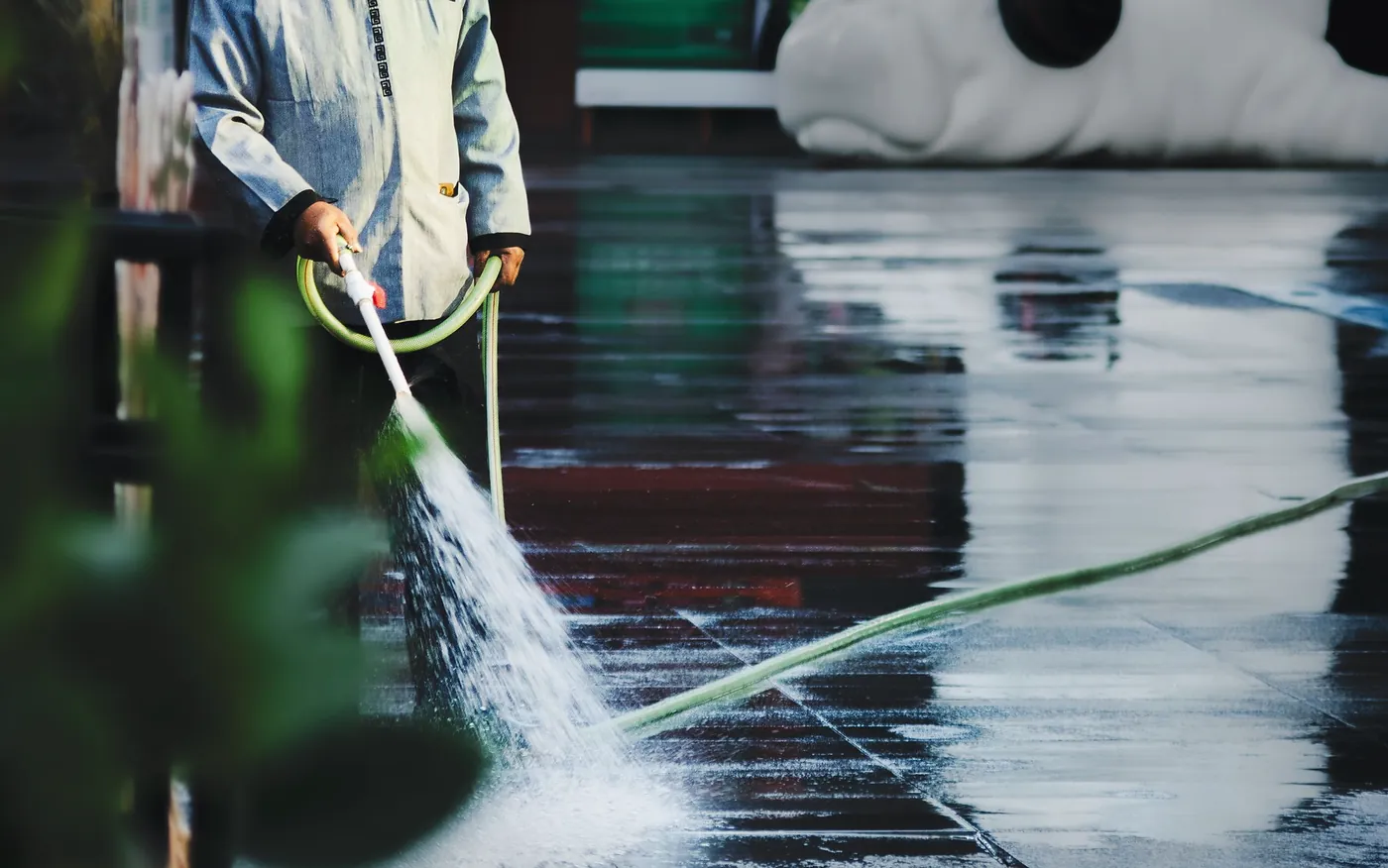 Water being directed across a wet hard surface during cleaning